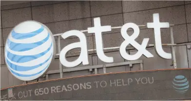  ?? AP FILE PHOTOS ?? CONSOLIDAT­ION: AT&T, one of its stores shown above, and Time Warner, its New York building shown below right, are cleared to merge in a $85 billion deal, a judge ruled yesterday.