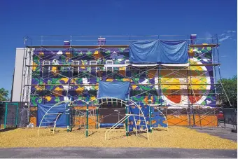  ?? ADOLPHE PIERRE-LOUIS/JOURNAL ?? The 30-foot mural “In the Garden of Sharing” takes shape on the east wall of the Albuquerqu­e Community Foundation. The concept is based on a natural landscape of flowers, vines, trees, birds and insects.