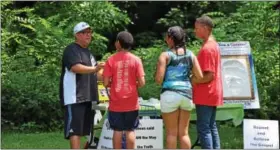  ?? MARIAN DENNIS — DIGITAL FIRST MEDIA ?? Andre Goff with Christian Collegian Network speaks with guests at one of the many tables set up Saturday in Riverfront Park meant to be used as community resources. Among some of the other tables were Pottstown School District , the Women’s Center of...