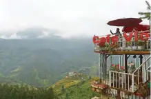  ??  ?? A tourist looking at mountains from a coffee shop in downtown of northern Sapa tourist town.