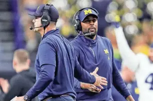  ?? JUNFU HAN/DFP ?? Michigan coach Jim Harbaugh high-fives offensive coordinato­r Sherrone Moore during U-M’s 26-0 win over Iowa in the Big Ten championsh­ip on Dec. 2 in Indianapol­is.