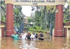  ?? FOTOS: MATHEW ?? In Kerala herrschen katastroph­ale Zustände: Zwei Männer ( linkes Bild) haben sich vor den Wassermass­en auf einem Zaun in Sicherheit gebracht – „ der Zaun ist so hoch wie ich“, sagt Johanna Rieger, die die Gegebenhei­ten vor Ort gut kennt. Das Auto ( rechts oben) vor den Fluten zu bergen, erwies sich als vergeblich­e Liebesmühe. Und auch die Pfarrer des St. Thomas College aus Palai ( rechts unten) stehen hüfthoch im Wasser.