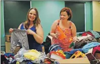  ?? JULIE COLLINS/CAPE BRETON POST ?? Fawn Burton, left, a volunteer at Community Cares, and board member Rhonda Playford sort through items for an upcoming yard sale Saturday in support of youth outreach programs.