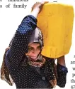  ?? AFP ?? A Syrian woman carries a container of water provided by UNICEF in Hasakeh after supply disruption.