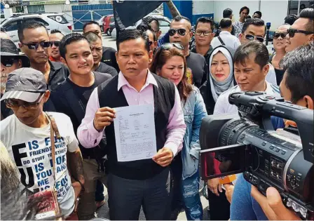  ??  ?? Reports made: Watson showing his police report against the TV3 presenter, who had made insulting remarks against his father on a national show, to members of the media in Miri.