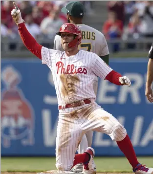 ?? LAURENCE KESTERSON — THE ASSOCIATED PRESS ?? The Phillies’ Rhys Hoskins conducts a celebrator­y chorus in the dugout after hitting an RBI double during the third inning Friday at Citizens Bank Park. The Phillies opened their season with a 9-5 win over the Oakland A’s.