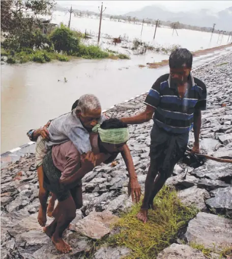  ?? Picture: AP ?? A villager carries an elderly man to safety after crossing floodwater­s in the eastern Indian state of Orissa
