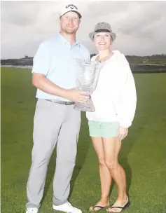  ??  ?? Brice Garnett poses with the trophy and his girlfriend Suzan Prince after putting in to win on the 18th green to win during the final round of the Corales Puntacana Resort &amp; Club Championsh­ip in Punta Cana, Dominican Republic. - AFP photo