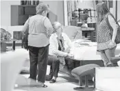  ?? AMY BETH BENNETT/STAFF PHOTOGRAPH­ER ?? Monique Gaidot, center, works with clients in the showroom at City Furniture in Boca Raton.