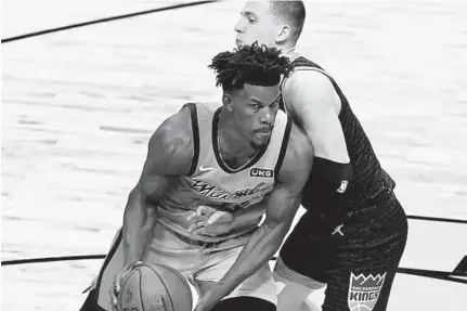  ?? MARTA LAVANDIER/AP ?? The Heat’s Jimmy Butler, right, works Saturday night against the Kings’ Kyle Guy.