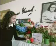  ?? Foto: dpa ?? Aylin, Schülerin der Berliner Anne Frank Grundschul­e, stellt neben einem Bildnis von Anne Frank Blumen und einen gemalten Geburtstag­sgruß ab.