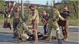  ?? (aFP) ?? Ukrainian service members being searched by pro-Russian military personnel in Mariupol on Tuesday