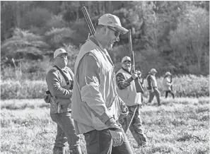  ?? THE BRAND AMP ?? Joe Thomas, foreground, shares stories with military veterans Mark Schroeder, left, and James Ardle while pheasant hunting during the Heroes Hunt last month at LEEK Hunting &amp; Mountain Preserve in Pennsylvan­ia.