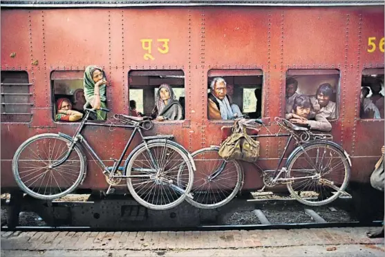  ??  ?? 1 Devotee carries a statue of Lord Ganesha into the waters of the Arabian Sea during the immersion ritual off Chowpatty beach; Mumbai, 1993 2 Bicycles hang on the side of a train; West Bengal,
1983 3 Rabari tribal elder; Rajasthan, 2010 4 Mahouts...