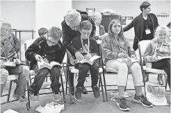  ?? CHRIS DUNN/ YORK DAILY RECORD/ USA TODAY NETWORK ?? Volunteer Carol Corwell helps Hunter Naugle, 10, find a verse in his Bible during “released time” in Hellam, Pa.
