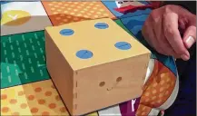  ?? RYAN NAKASHIMA / ASSOCIATED PRESS ?? A Cubetto robot crosses a table following commands input into a board using blocks at January’s CES gadget show in Las Vegas. Cubetto responds to where chip-embedded pieces are put on a wooden board.