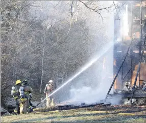  ?? TIMES photograph­s by Annette Beard ?? Firefighte­rs from Rogers, Pea Ridge, Little Flock, Avoca and NEBCO worked together to extinguish the blaze that destroyed the home of James and Marilyn Whisenhunt on Patterson Road north of Pea Ridge.