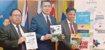  ??  ?? SALAHUDDIN (tengah) menunjukka­n buku DPP pada majlis Pelancaran Dokumen Pengembang­an Perikanan (DPP) Jabatan Perikanan Malaysia.