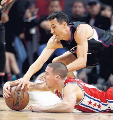  ?? Gina Ferazzi Los Angeles Times ?? PHILADELPH­IA GUARD T. J. McConnell is f irst on the f loor as he and the Clippers’ Pablo Prigioni scramble after a loose ball during the second half at Staples Center.