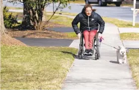  ?? ?? Tatyana McFadden takes Bentley for a walk near her family’s home in Clarksvill­e. KIM HAIRSTON/THE BALTIMORE SUN