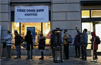  ?? ANDREW HARRER / BLOOMBERG ?? Customers wait in line outside a restaurant opened for federal workers and their families during a partial government shutdown in Washington D.C. on Thursday.