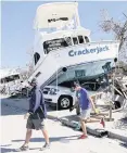  ?? AL DIAZ adiaz@miamiheral­d.com ?? Hurricane Ian lifted the charter boat ‘Crackerjac­k’ on top of a car on San Carlos Island off the coast of Fort Myers.