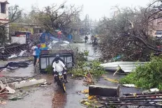  ?? Reuters ?? People move through debris on a road after Cyclone Fani hit Puri city.