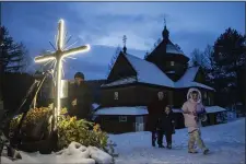  ?? EVGENIY MALOLETKA — THE ASSOCIATED PRESS ?? A woman with her children walk after church Christmas service in Kryvorivni­a village, Ukraine, Sunday, Dec. 24, 2023.
