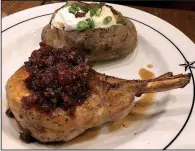  ?? Arkansas Democrat-Gazette/JENNIFER CHRISTMAN ?? A Double Bone Smoked Pork Chop, topped with bacon jam, is served with a loaded baked potato at Saltgrass Steak House.