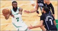  ?? Michael Dwyer / AP ?? The Celtics’ Jaylen Brown, left, passes as the Magic’s Michael Carter-Williams defends during the first half on Sunday in Boston.