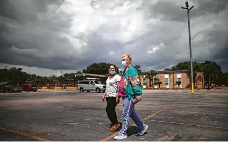  ?? Marie D. De Jesús / Staff photograph­er ?? Jacquelyn Guyton, right, and Debbie Saldana walk to St. Charles Borromeo Church, where renters were assisted in applying for aid.