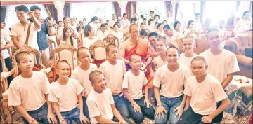  ?? — AFP photo ?? Ekkapol (centre) and all 12 members of the ‘Wild Boars’ football team pose for a photo together after a ceremony to mark the end of the 11 players’ retreat as novice Buddhist monks at the Wat Phra That Doi Tung temple in the Mae Sai district of Chiang...