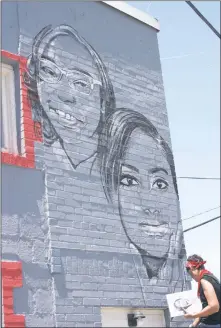  ?? STAFF PHOTO BY PAUL LAGASSE ?? Artist Lori Pratico of the “Girl Noticed” Mural Project drew the faces of three notable young local women on the side of the Black Box Theater in Indian Head on Saturday.