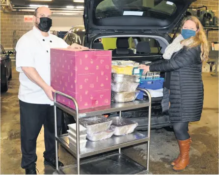  ??  ?? Tony Earl, chef manager at Wessex Water, hands over the meals for the Julian House hostel to Cathy Adcock from the homeless charity