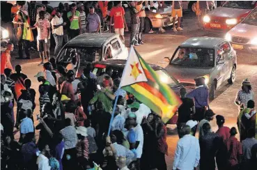  ?? [AP PHOTO] ?? Zimbabwean­s celebrate Tuesday in the streets of Bulawayo, Zimbabwe, after hearing the news that President Robert Mugabe had resigned. Mugabe resigned Tuesday, effective immediatel­y, after 37 years in power.