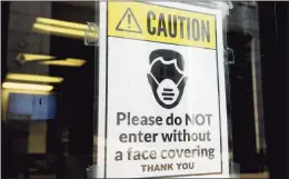  ?? Ned Gerard / Hearst Connecticu­t Media ?? A sign requiring masks or face coverings hangs on the front door of the Morton Government Center in Bridgeport on Aug 11.