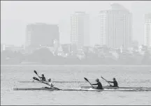  ?? NHAC NGUYEN / AFP ?? Men row their boats on West Lake amid high levels of air pollution in Hanoi on April 1.