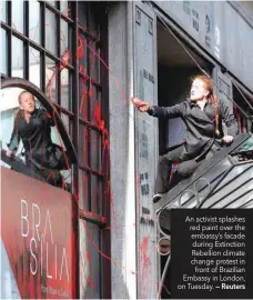  ?? — Reuters ?? An activist splashes red paint over the embassy’s facade during Extinction Rebellion climate change protest in front of Brazilian Embassy in London, on Tuesday.