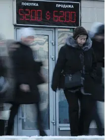  ?? DMITRY LOVETSKY/THE ASSOCIATED PRESS ?? People walk past a currency display board in St. Petersburg. The Russian ruble fell sharply last year.