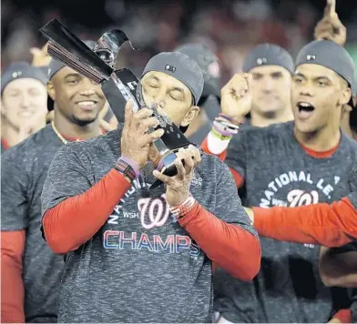  ?? JEFF ROBERSON/AP ?? Nationals manager Dave Martinez, a Lake Howell grad, kisses the NLCS trophy after a sweep of the Cardinals on Oct. 15.