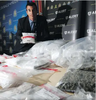  ?? LEAH HENNEL ?? Staff Sgt. Garth Kowalyk of the Alberta Law Enforcemen­t Response Team displays, at CPS Headquarte­rs on Tuesday, some of the drugs that police seized in a raid of three homes last week.