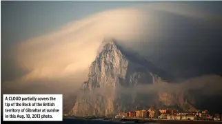  ?? REUTERS ?? A CLOUD partially covers the tip of the Rock of the British territory of Gibraltar at sunrise in this Aug. 18, 2013 photo.