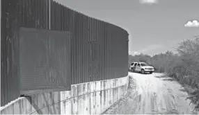  ??  ?? A Customs and Border Patrol vehicle passes along a section of border levee wall in Hidalgo, Texas. ERIC GAY/AP