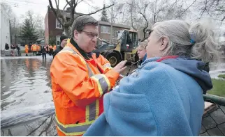  ?? PETER MCCABE ?? Montreal Mayor Denis Coderre speaks with residents of rue Cousineau in the Ahuntsic-Cartiervil­le borough of Montreal, after declaring a state of emergency on Sunday because of rising flood waters.