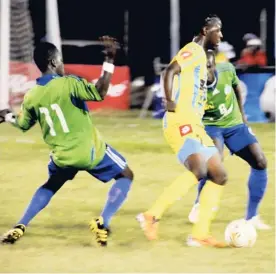  ?? FILE ?? Waterhouse’s Weston Forrest ( centre) tries to move away from Montego Bay United’s Troy Reid ( left) and Leon Irving during their Red Stripe Premier League last season.