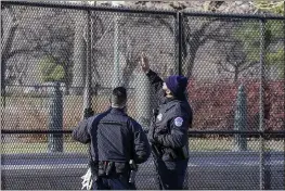  ?? JOHN MINCHILLO — THE ASSOCIATED PRESS ?? Capitol police officers look at fencing that was installed around the exterior of the Capitol grounds in Washington on Thursday.