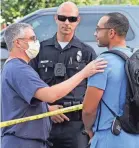  ?? AP ?? Hospital staff talk to a police officer after a suspect in a stabbing was barricaded in the Encino Hospital Medical Center in California.