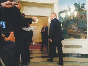  ?? AP PHOTO ?? President Donald Trump talks with reporters as he leaves the room after signing a Presidenti­al Memorandum imposing tariffs and investment restrictio­ns on China in the Diplomatic Reception Room of the White House, Thursday.