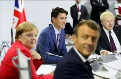  ?? SEAN KILPATRICK — THE CANADIAN PRESS VIA AP ?? Canadian Prime Minister Justin Trudeau, second from left, German Chancellor Angela Merkel, left, President of France Emmanuel Macron, second from right, and British Prime Minister Boris Johnson take part in a working session with G7 leaders on the second day of the G-7 summit Sunday in Biarritz, France.