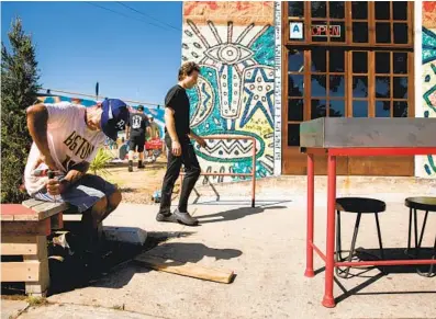  ?? SAM HODGSON U-T ?? Jose Gonzalez helps the owners of Hayes Burger by working on a bench installed in front of the restaurant for patio dining in Barrio Logan on Wednesday. Indoor restaurant dining is restricted under new state public-health orders.